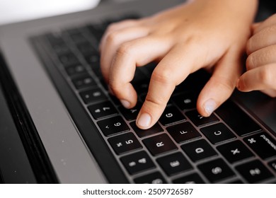 Close-up of children's hands typing on a laptop keyboard. Perfect for educational content, technology use by kids, or highlighting early learning in a digital age. - Powered by Shutterstock - Get 15% off with code: PIKWIZARD15