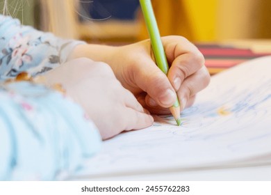 Close-up of a child's hands drawing with colored pencils. Children's creativity and development, fine motor skills, learning to write and draw. - Powered by Shutterstock