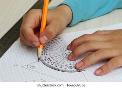 Closeup Child's Hands Measuring Angle By Protractor.