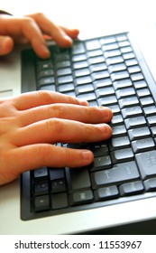 Close-up Of Child's Hands Typing On Laptop Keyboard