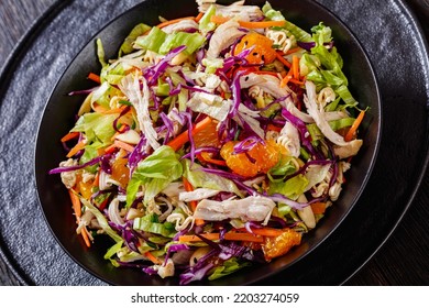 Close-up Of Chinese Chicken Salad With Shredded Chicken Meat, Mandarin Oranges, Crunchy Noodles, Red Cabbage, Napa Cabbage, Carrots, Green Onions In Bowl