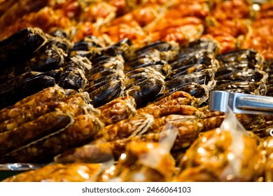 a close-up of Chinese-style sausages hung in an orderly fashion at a market stall - Powered by Shutterstock