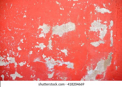 closeup of chipped paint on red wall