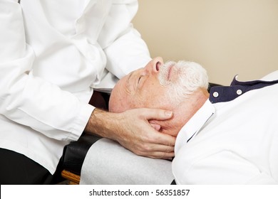 Closeup of a chiropractor adjusting a senior patient's cervical spine (neck). - Powered by Shutterstock