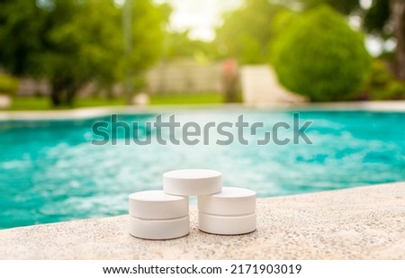 Closeup of chlorine tablets for swimming pool cleaning, chlorine tablets on the edge of a swimming pool, chlorine tablets for swimming pool disinfection

