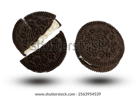 A close-up of an Chocolate cookie, split in half, revealing the creamy filling. Isolated on a white background.