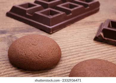 Close-up chocolate cookies with pieces of dark chocolate on rustic wooden table
