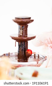 Closeup Of Chocolate Fondue Fountain With One Strawberry On Stick