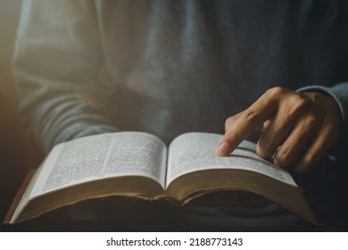 Close-up of Christian man's hands while reading the Bible outside.Sunday readings, Bible education. spirituality and religion concept. Reading a book.