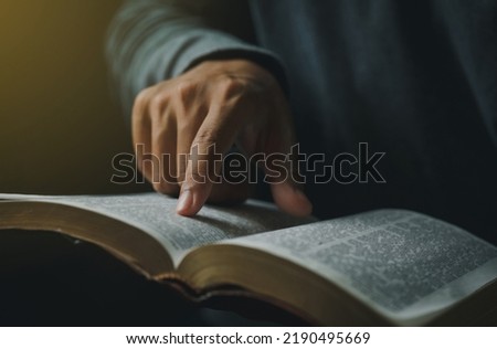 Close-up of Christian man's hands while reading the Bible outside.Sunday readings, Bible education. spirituality and religion concept. Reading a book.