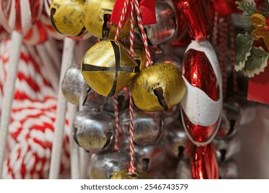 a close-up of Christmas decorations, including gold and silver jingle bells, red and white candy cane ornaments, and other festive items. The decorations are vibrant and evoke a holiday spirit. - Powered by Shutterstock