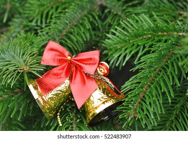 Closeup of Christmas-tree with gold bells and red bow decorations - Shutterstock ID 522483907