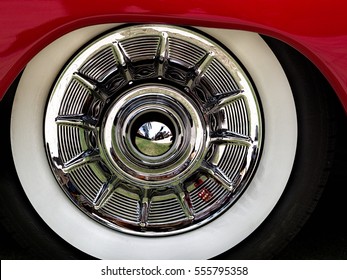 Closeup of a chrome hubcap with a whitewall tire on a red car at a car show in Boca Raton FL