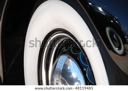 Closeup of the chrome rims with whitewall tire