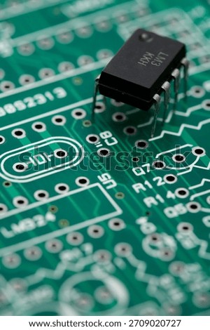 Close-up of a circuit board with a microchip highlighting electronic components and connections in a tech workshop