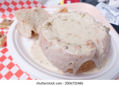 Closeup Of Clam Chowder Spilling Out Of A Bread Bowl. Seattle Famous Chowder On A Takeout Paper Plate, Overflowing Due To Generous Portions.