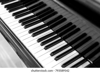 Closeup of a classical musical piano keyboard in a diagonal composition with nobody and a copyspace area for music song writing based designs and themes in black and white