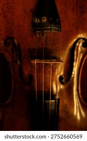 Close-up of Classical Violin Strings and Tailpiece with Warm Ambient Lighting