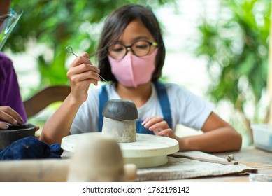 Closeup clay work with blurred little student learning in the workshop class. Classroom with new normal concept - Powered by Shutterstock