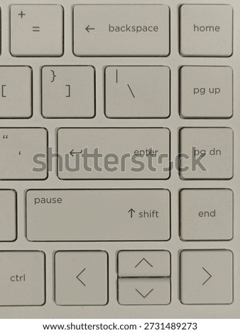 Close-up of a clean white computer keyboard showing backspace, enter, shift, and arrow keys. Minimalist tech background ideal for productivity, workspace, UI, and digital concept designs.