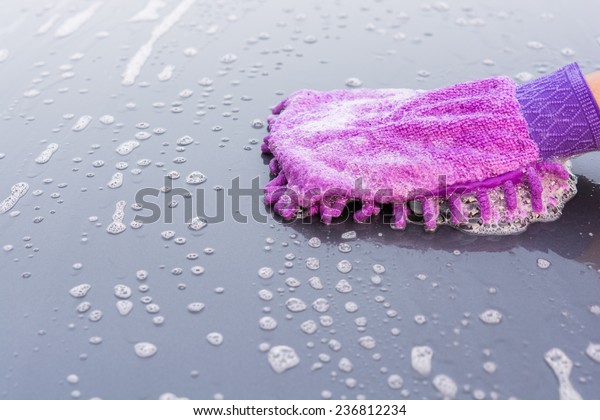 Closeup\
cleaning his car using gloves car wash gray\
color