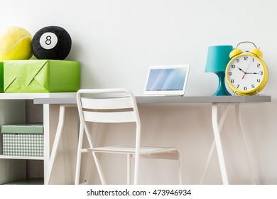 Close-up Of A Clear Desk Space In A Children's Room, With A Grey Desk And A White Plastic Chair