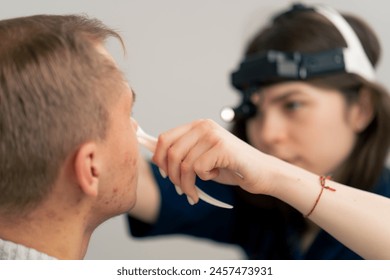 close-up in the clinic young doctor ear throat nose examines the patient s nose - Powered by Shutterstock