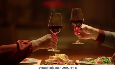 Closeup Clinking Wine Glasses In Senior Couple Hands. Grandparents Toasting Wine Glasses In Restaurant. Mature Couple Date Home. Rich Old People Enjoy Retirement Time. Old Aged Couple Romantic Dinner 