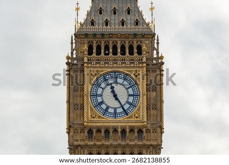 A close-up of the clock section of the Big Ben on a cloudy day, London.
