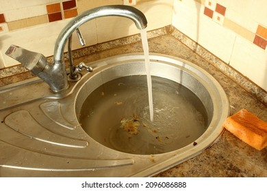 Close-up Of A Clogged Kitchen Sink With Food Waste.