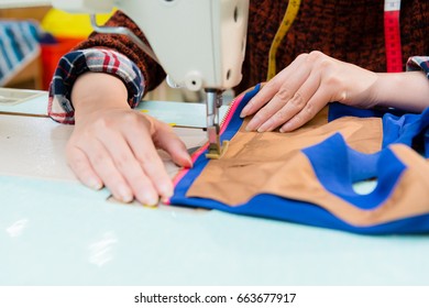 closeup of clothing factory employee woman holding dress sample using tailor machine making for company new season product with selective focus photo. - Powered by Shutterstock