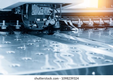 Close-up of the CNC punching machine in the light blue scene.High technology metal forming process.
