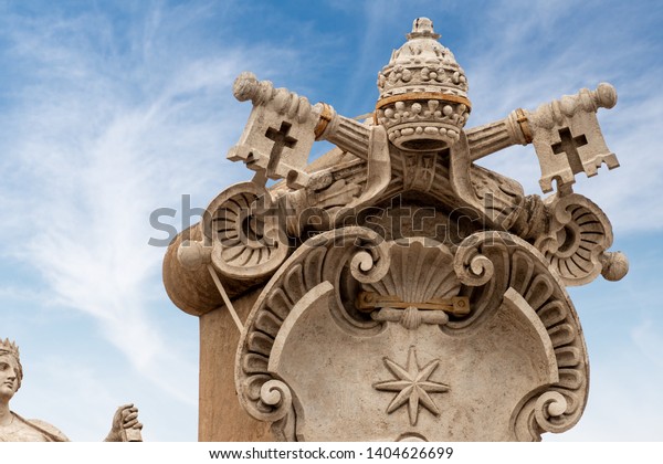 Close-up of the Coat of arms of the Vatican city with the papal Tiara, the shield and the two keys with a cross. Colonnade of the Basilica of Saint Peter, Rome, Latium, Europe