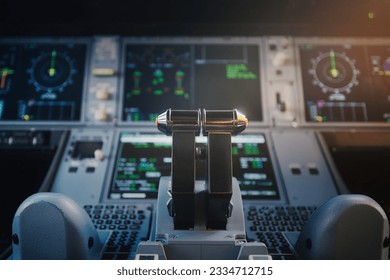 Close-up of cockpit of commercial airplane. Selective focus on engine thrust levers against illuminated control panel of modern plane.