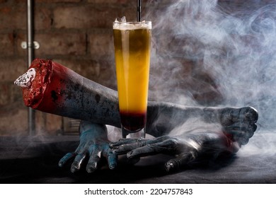 A Closeup Of A Cocktail Against Creepy Hand Mannequins In Smoke