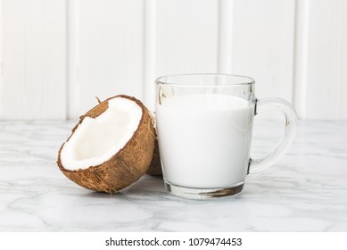 Closeup Of Coconut Milk In A Glass And Coconut Halves