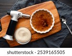 Close-up of Coffee creme Brulee with Torch and Sugar: Torched coffee creme brulee with a kitchen torch and dish of organic granulated sugar