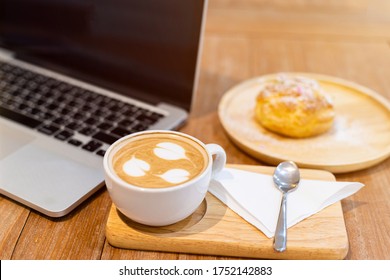 Close-up Of With Coffee Cup Working With Laptop Computer And Homemade Profiteroles With Choux Cream In Coffee Shop Like The Background,Snack During Work Concept