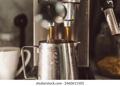Close-up of coffee from a coffee machine. The coffee machine fills a metal cup with espresso. Professional coffee brewing. An invigorating drink. selected focus. High quality photo - Powered by Shutterstock
