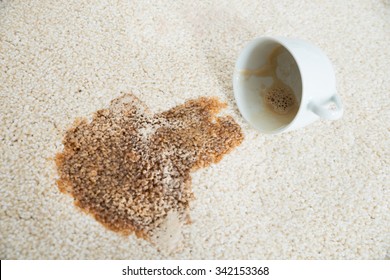Close-up of coffee spilling from cup on carpet