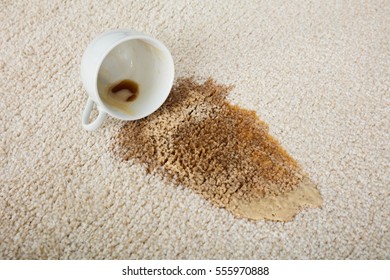 Close-up Of Coffee Spilling From Cup On Carpet