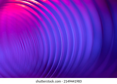 Closeup Of Coiled Metal Spring With Sufficiently High Strength And Elastic Properties In Neon Blue And Pink Light. Macro Photo, Selective Soft Focus. Abstract Shot.