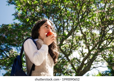 Close-up Of College Girl Eating An Apple In Campus. Shot From Below And Copy Space