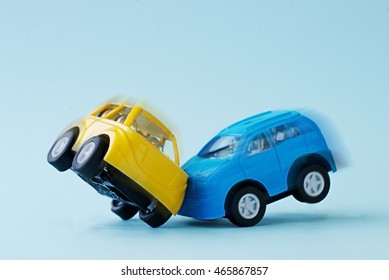 Close-up Of A Collision Of Two Toy Cars On A Blue Background