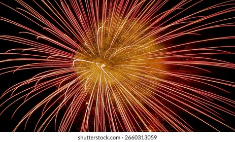Close-up color photo of an exploding firework with time lapse photography showing glowing red light trails and golden sparks against a dark black sky background.