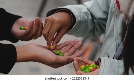 Close-up of colored candy or chewing gum. Children hold a bunch of colorful candies in their hands. Children share sweets among themselves - Shutterstock ID 2222581349