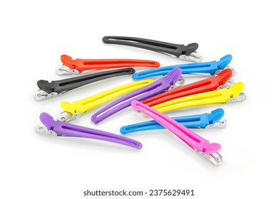Closeup of colorful duckbill hair clips on white background. Hair styling accessories in different colors, used in salon or at home to clamp sections and style hair. 