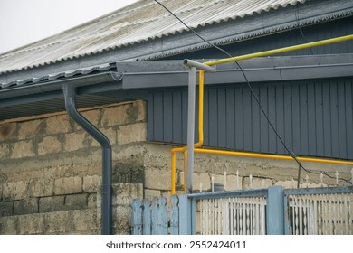 Close-up of a colorful gas pipe against a rustic building facade. - Powered by Shutterstock