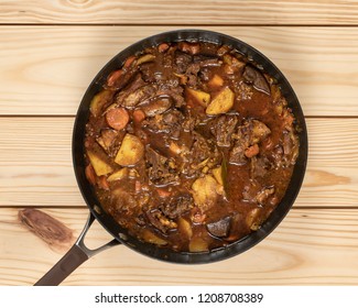 Close-up Of Colorful Goat Stew In Cooking Pan On Top Of  Wooden Table.