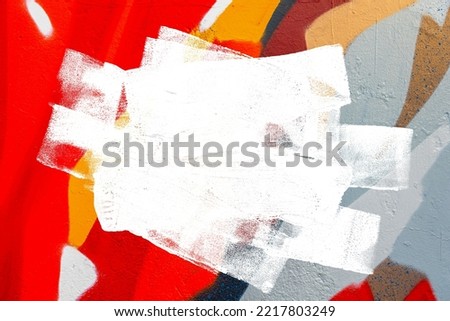 Closeup of colorful gray, orange, red urban wall texture with white white paint stroke. Modern pattern for design. Creative urban city background. Grunge messy street style background with copy space